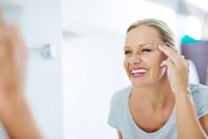 Woman looking at her skin in the mirror